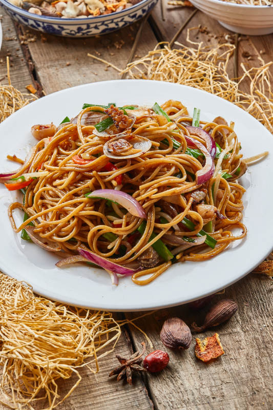 青瓷盘装的海鲜炒意大利面图片