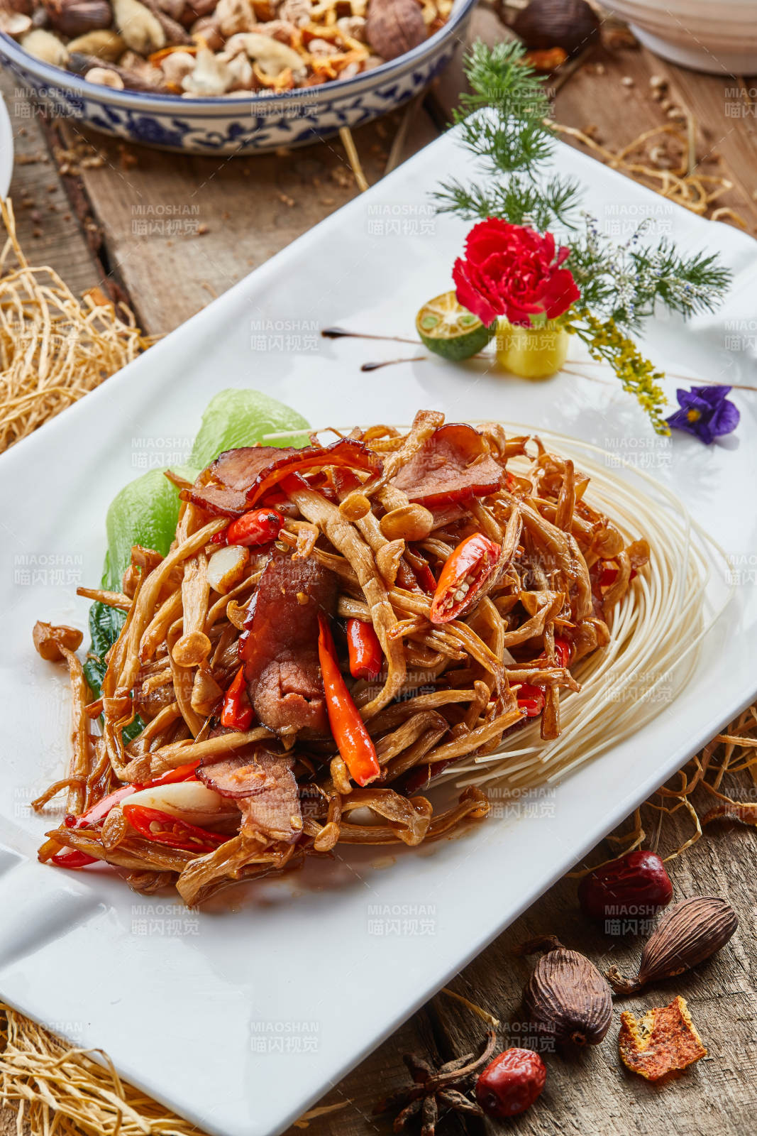 白色瓷盘的茶树菇蒜香炒腊肉图片