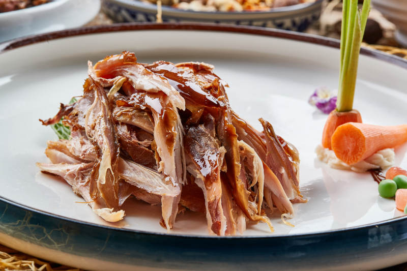 双色圆瓷盘装的手撕兔图片