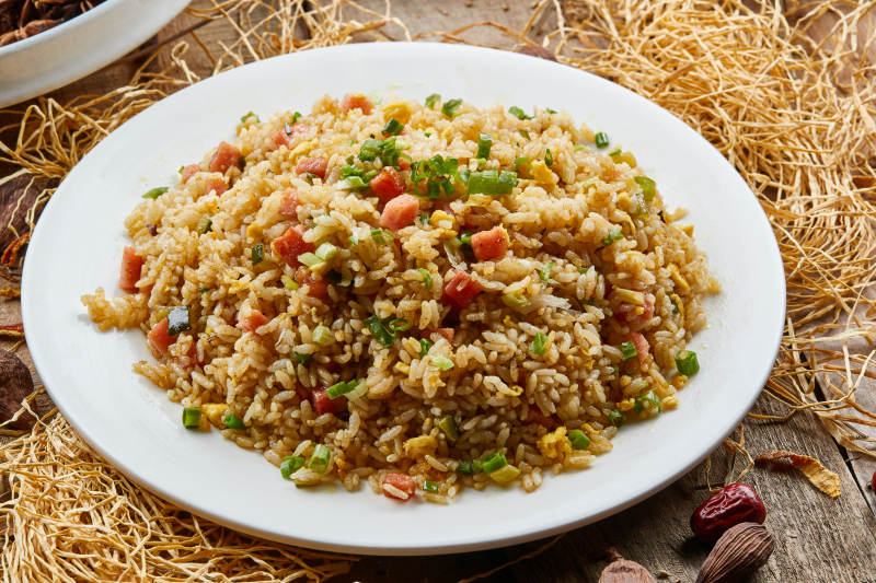 白色圆瓷盘装的扬州炒饭图片