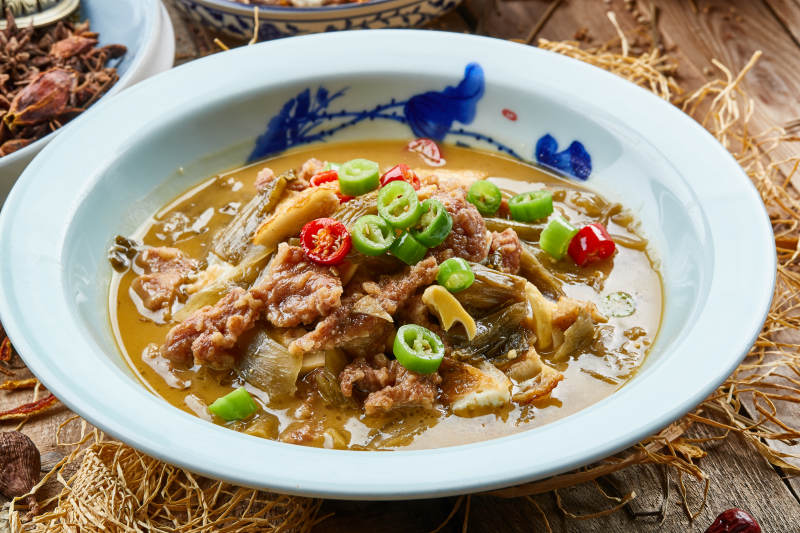 青瓷盘装的酸菜酸汤炖牛柳图片