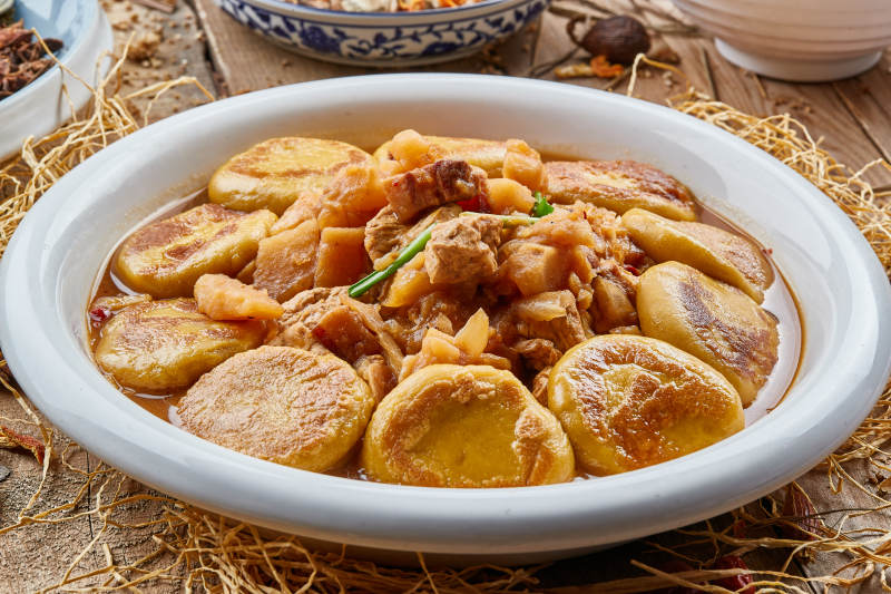 圆瓷盘装的农家炖菜配拿糕图片