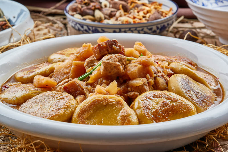 圆瓷盘装的农家炖菜配拿糕图片