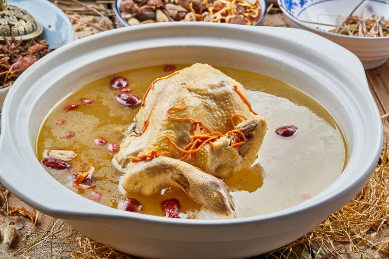 白色砂锅装的红枣虫草枸杞参鸡汤图片