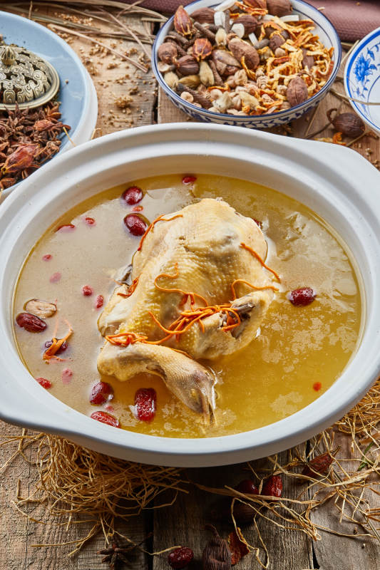 白色砂锅装的红枣虫草枸杞参鸡汤图片