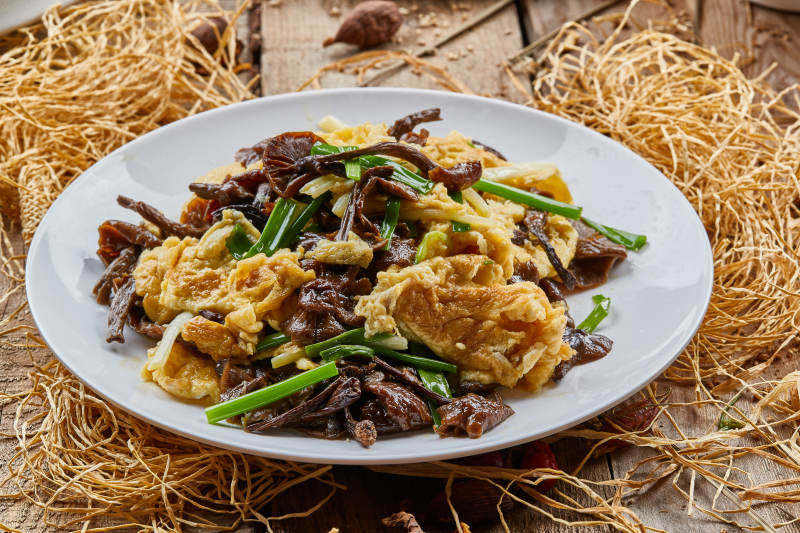 圆瓷盘装的松树菇炒柴鸡蛋图片