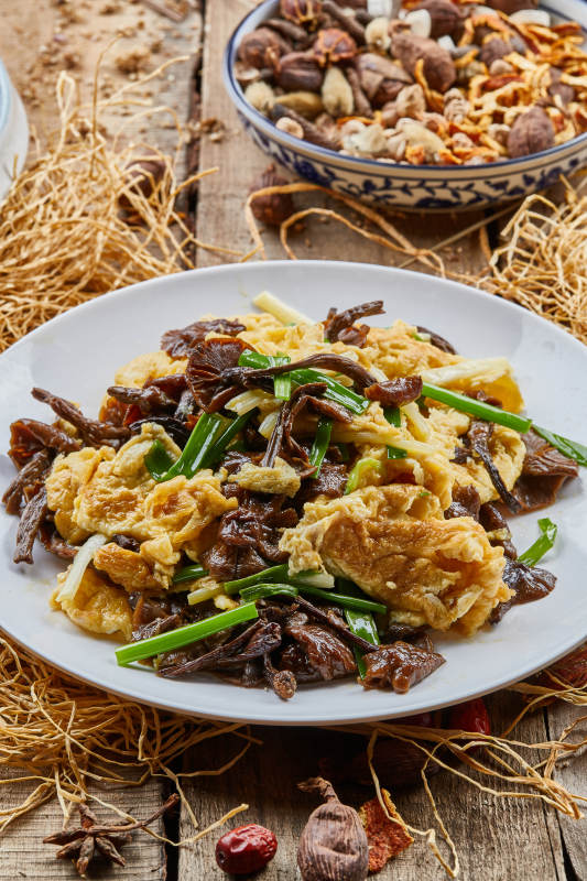 圆瓷盘装的松树菇炒柴鸡蛋图片