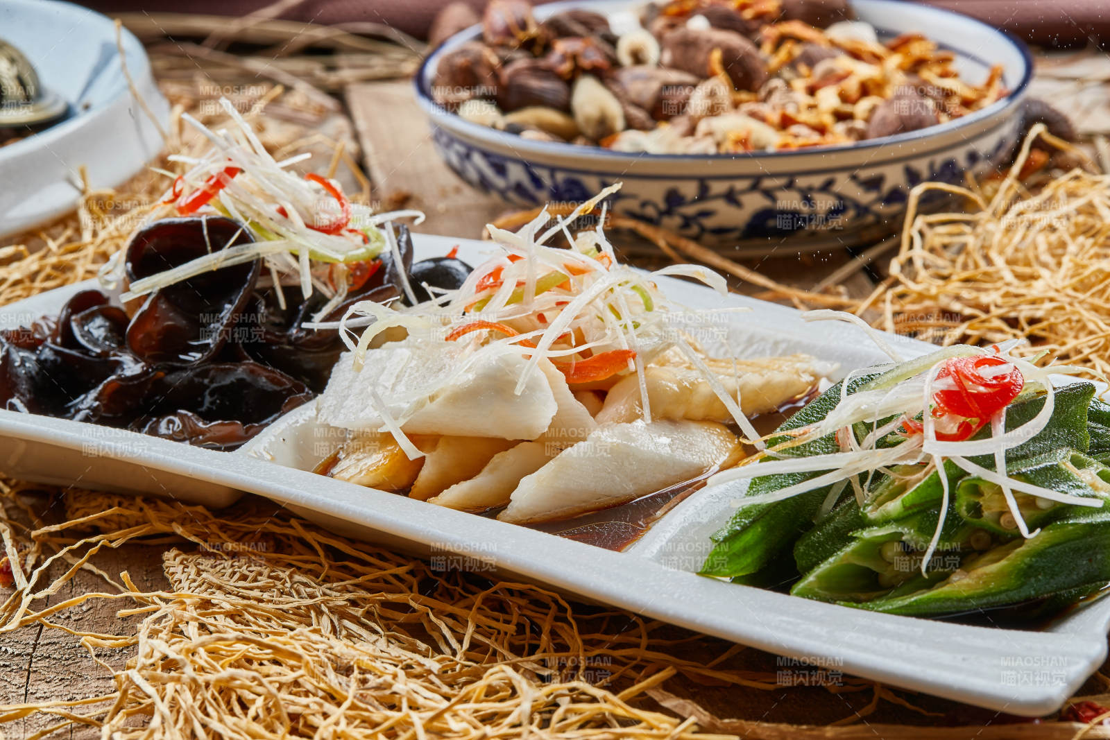 三格瓷盘装的酸辣小菜木耳山药秋葵图片