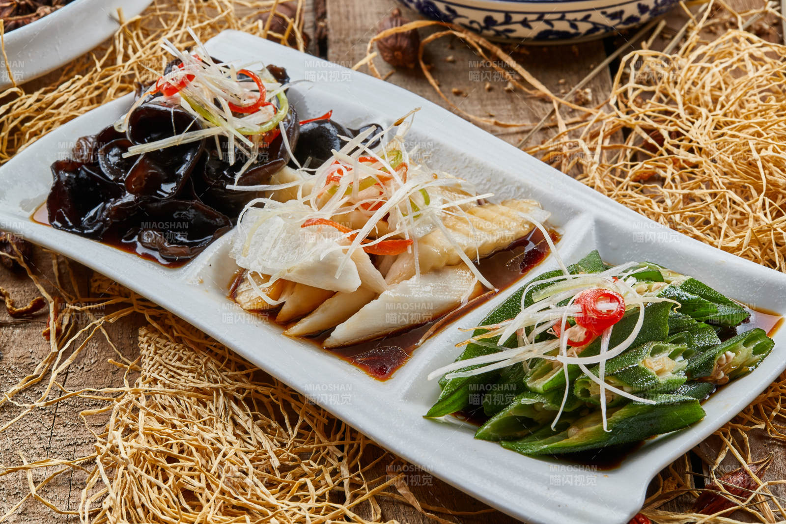 三格瓷盘装的酸辣小菜木耳山药秋葵图片