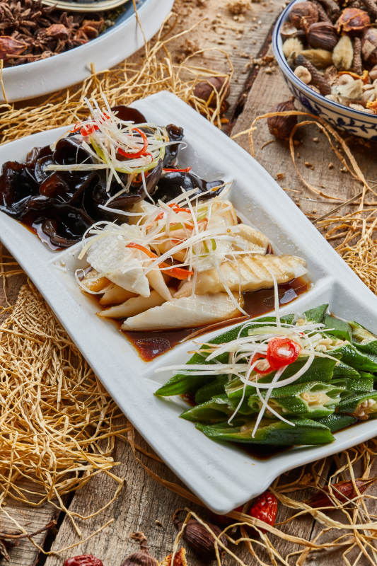 三格瓷盘装的酸辣小菜木耳山药秋葵图片