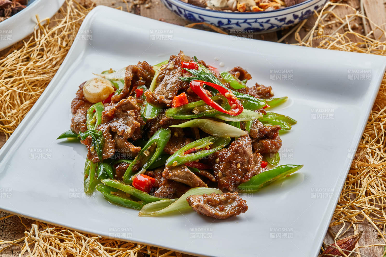 方青瓷盘装的蒜香辣炒牛柳图片