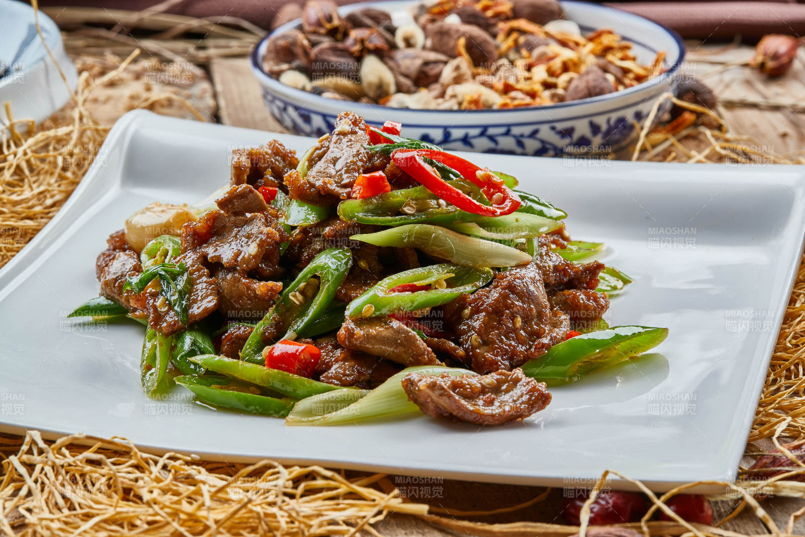 方青瓷盘装的蒜香辣炒牛柳图片