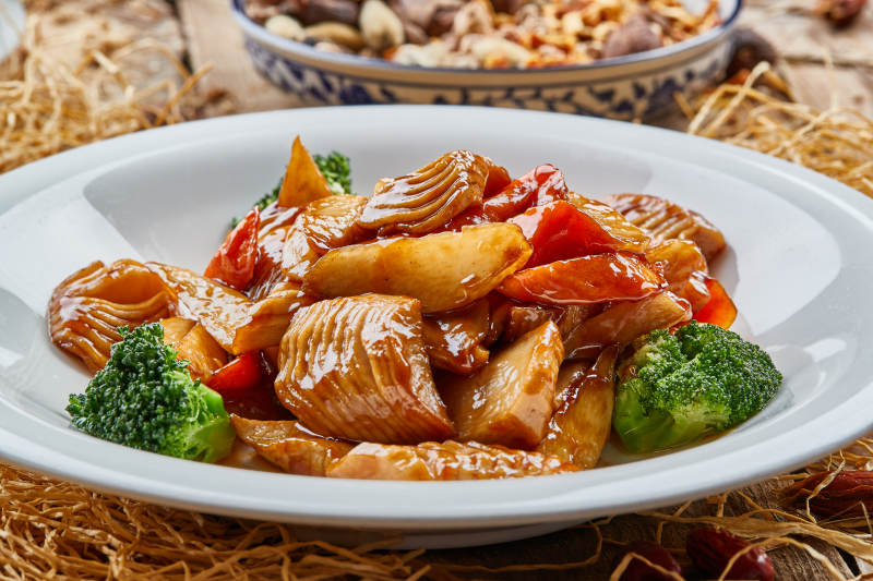 圆瓷盘装的土豆油爆笋图片