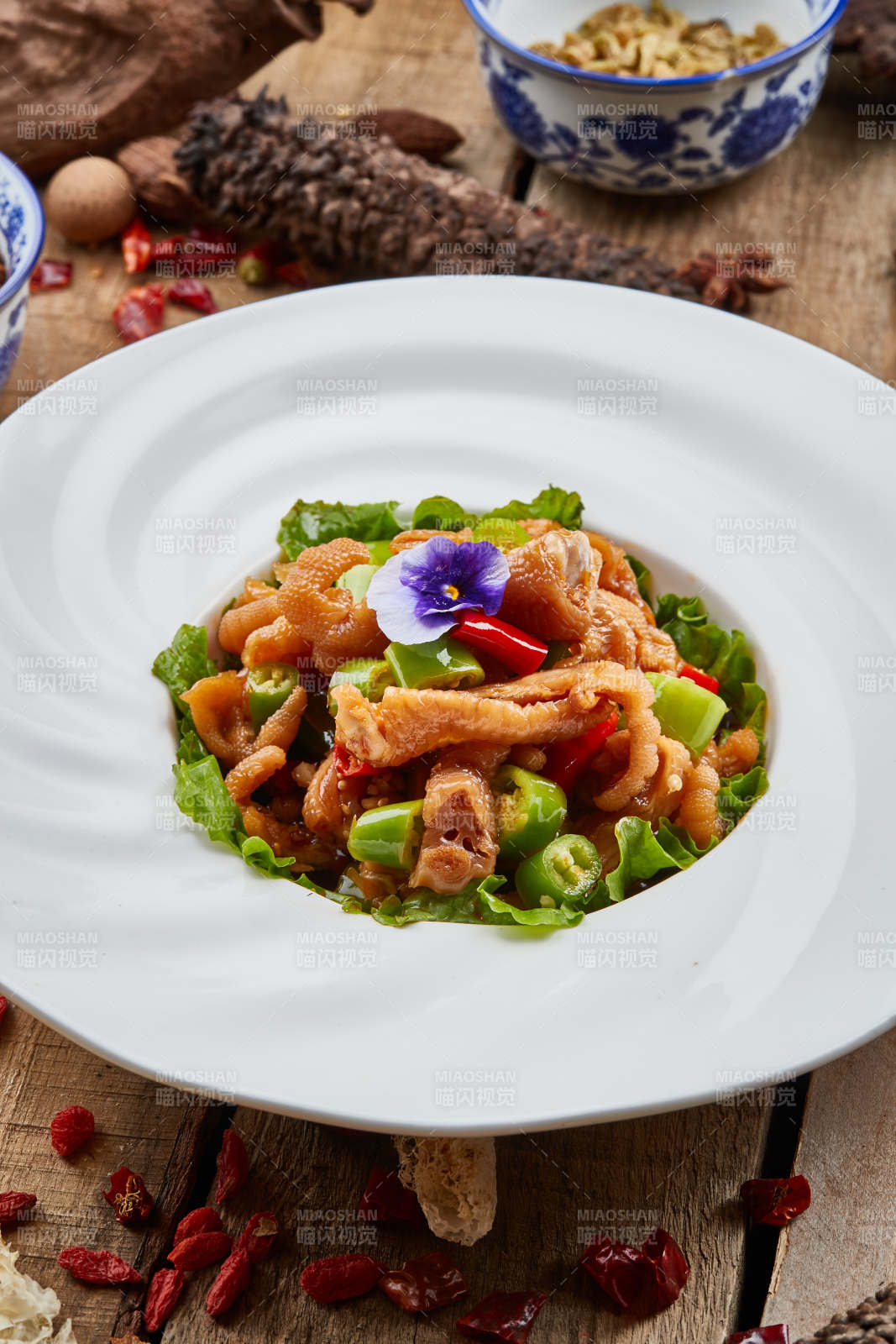 白色瓷盘装的红油酸辣脱骨凤爪图片