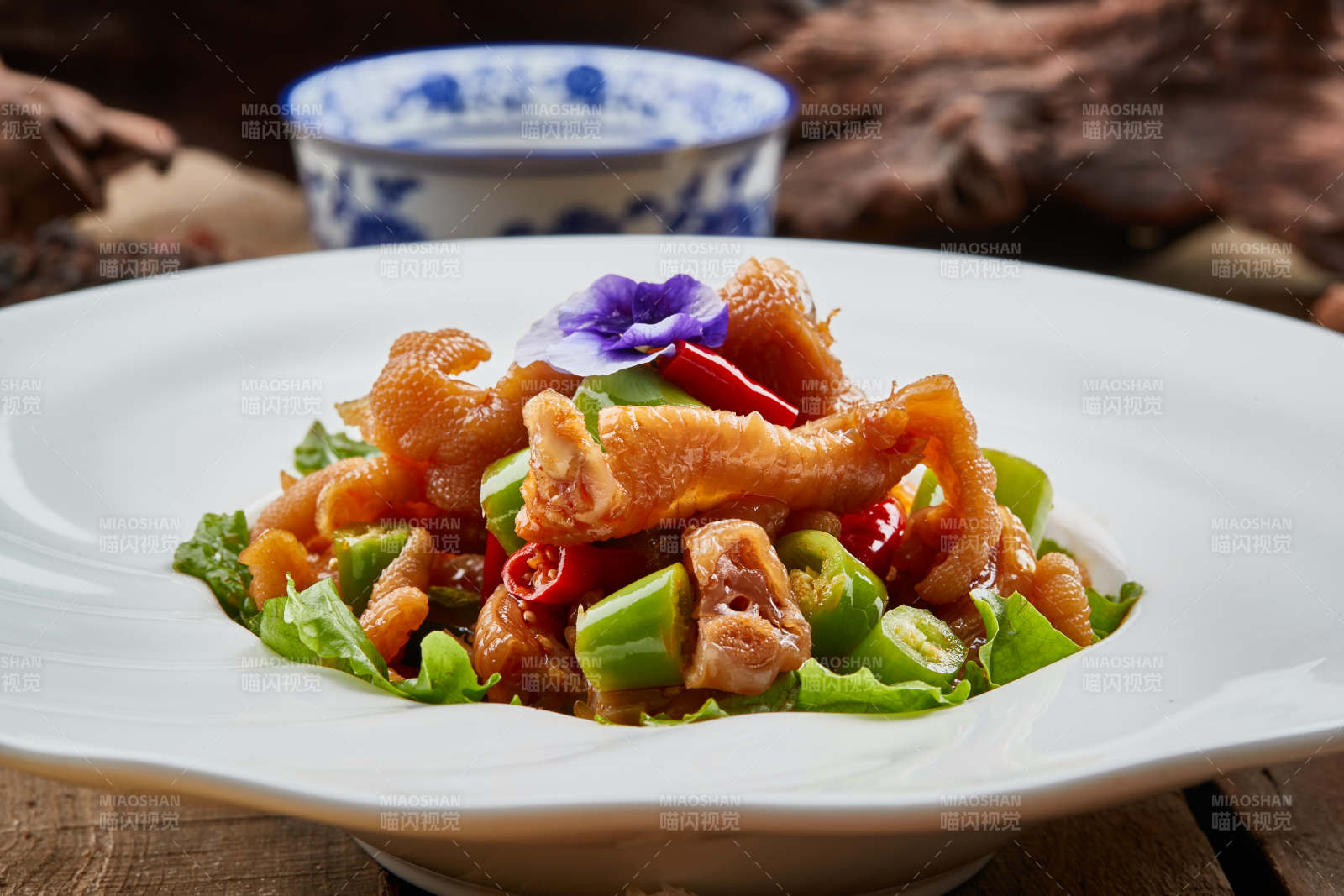 白色瓷盘装的红油酸辣脱骨凤爪图片