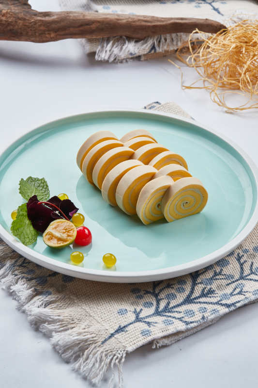 白色瓷盘组昂的豆腐皮熏肉卷切片图片