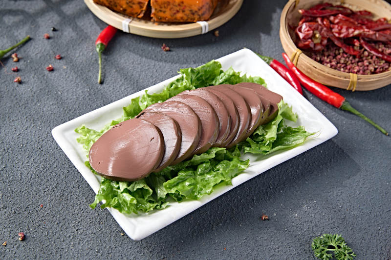 白色瓷盘装的火锅食材鸭血切片图片