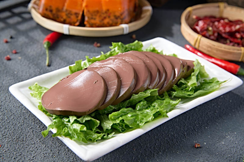 白色瓷盘装的火锅食材鸭血切片图片