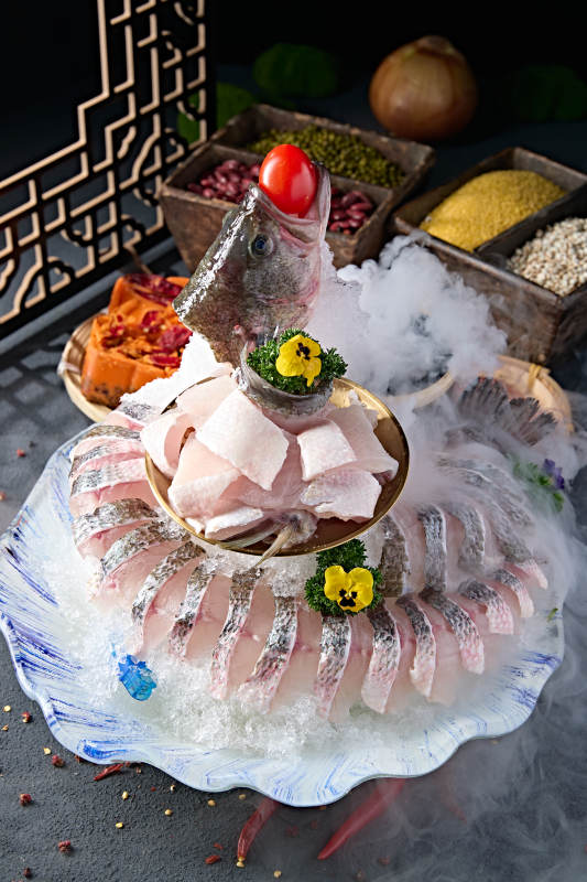 布满碎冰的青色瓷盘装的海鲈鱼刺身生鱼片图片