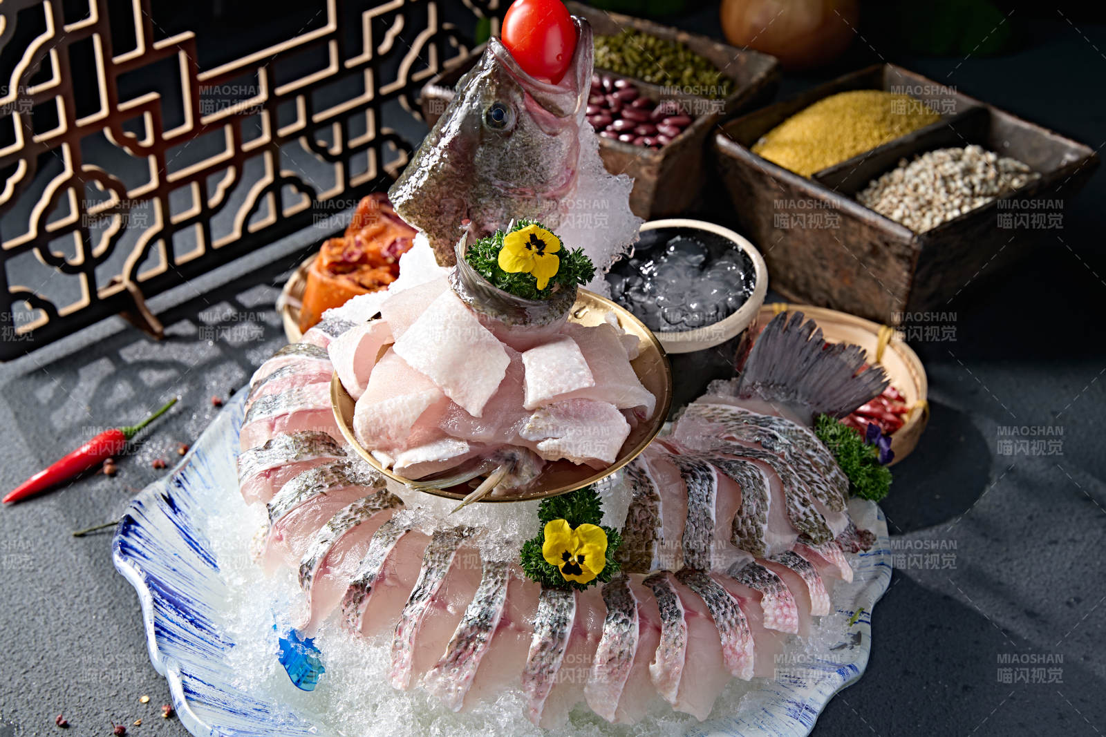 布满碎冰的青色瓷盘装的海鲈鱼刺身生鱼片图片