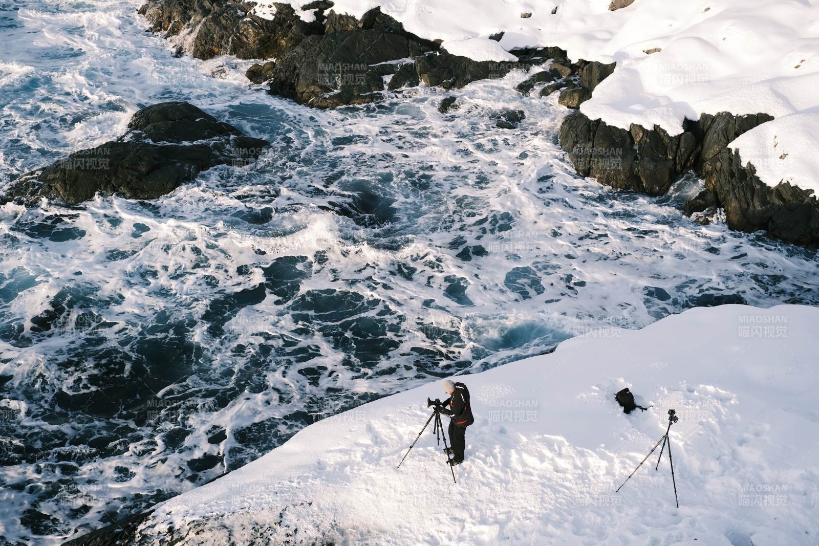 挪威雪崖边的摄影者图片
