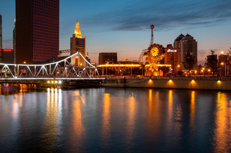 天津世纪钟夜幕下的城市河景图片