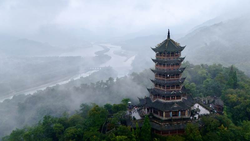 雾中古塔山河景图片