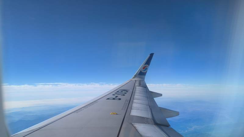 蓝天下的机翼翱翔图片