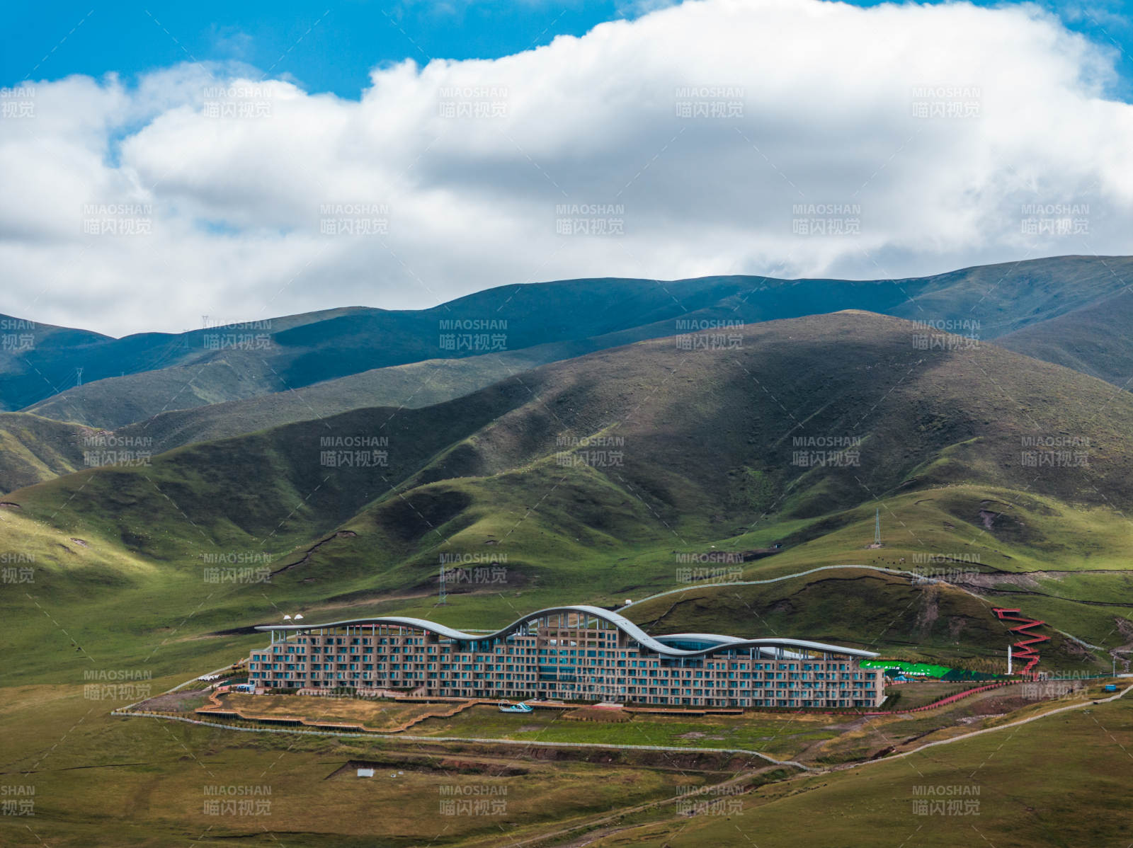 草原上现代建筑与连绵山脉蓝天白云自然景观图片