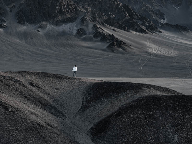 孤独旅人站立在荒凉山地眺望探索远方沙漠图片
