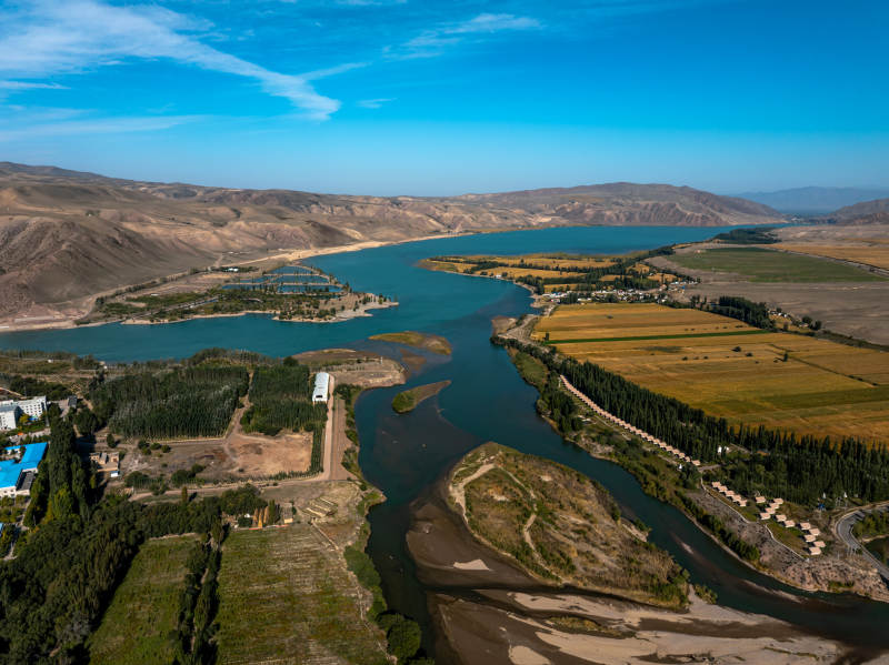 蜿蜒河流穿越新疆伊犁的绿洲与农田和谐自然图片