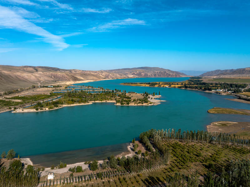 蜿蜒河流如丝带穿行伊犁绿洲农田间和谐美景图片