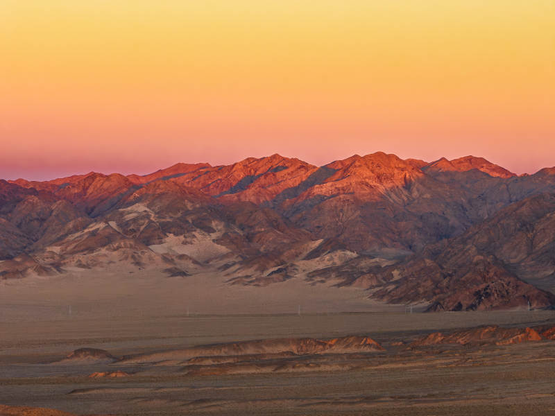 西北戈壁高原日落黄昏金色天空群山日照金山图片