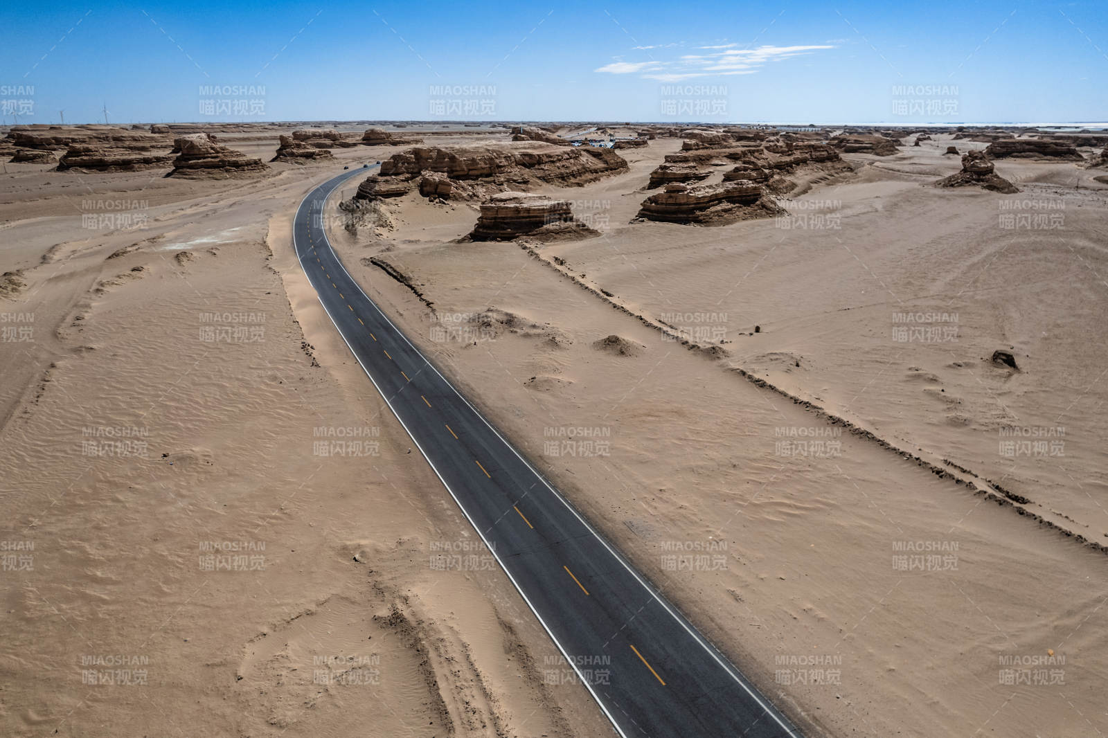 西北戈壁荒漠蜿蜒公路延伸到远方地平线航拍图片