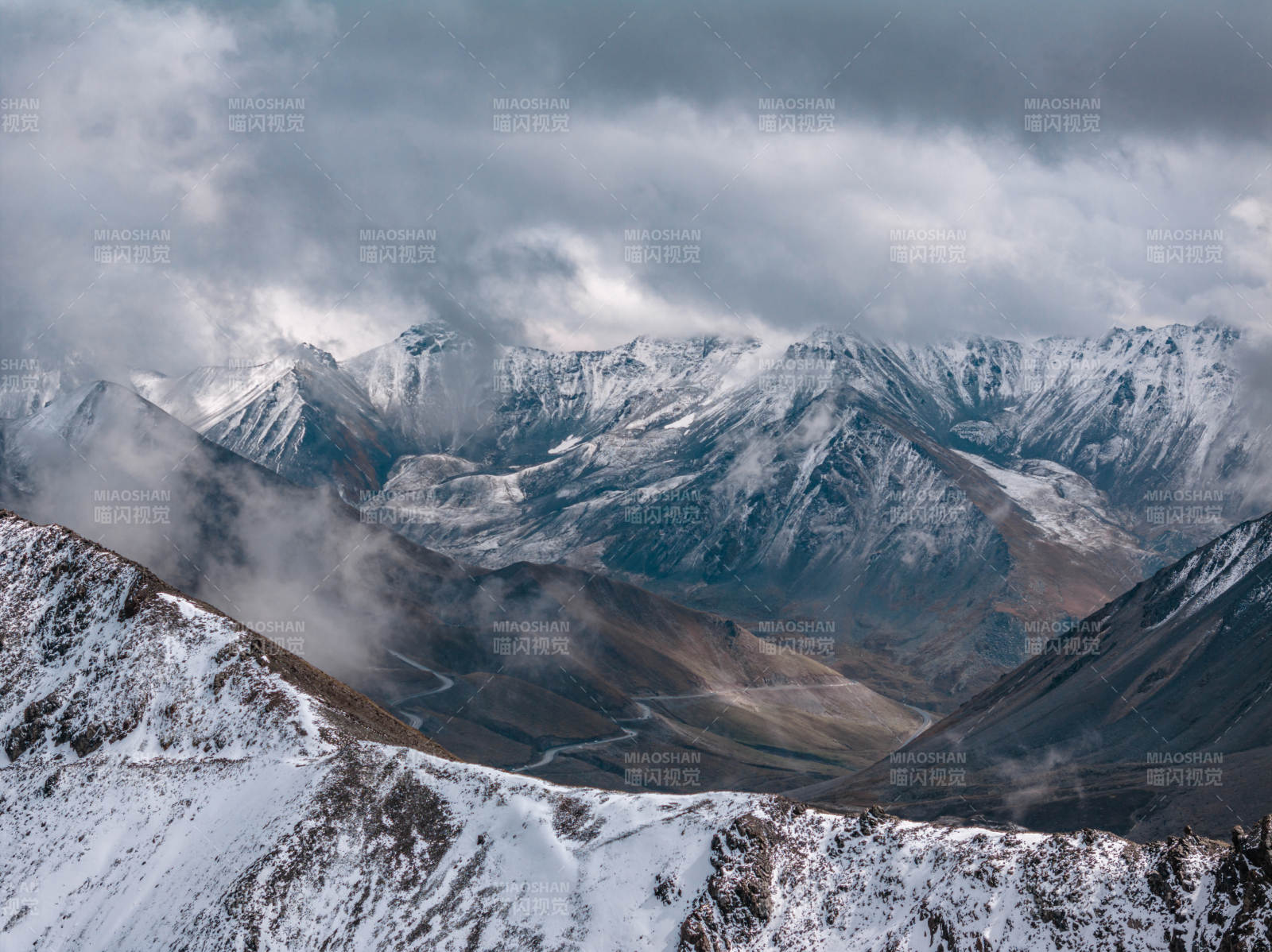 雪山云海间蜿蜒公路展现自然壮美与高原云雾图片