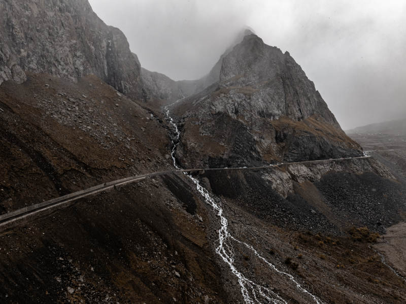 雨雾群山瀑布与蜿蜒公路交织的原始自然风光图片