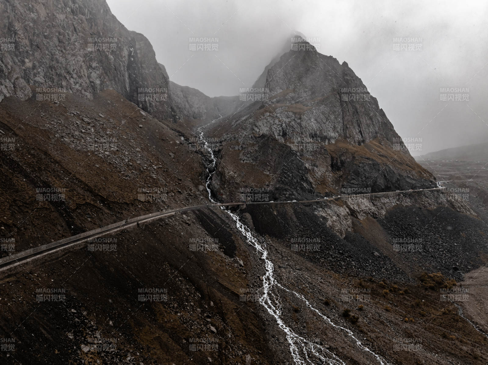 雨雾群山瀑布与蜿蜒公路交织的原始自然风光图片
