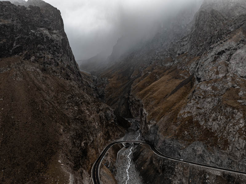 云雾缭绕山谷蜿蜒公路与岩石山峰的独库公路图片