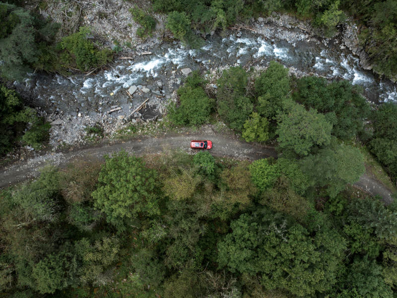 自驾汽车在山林溪流边穿越原始森林越野探险图片