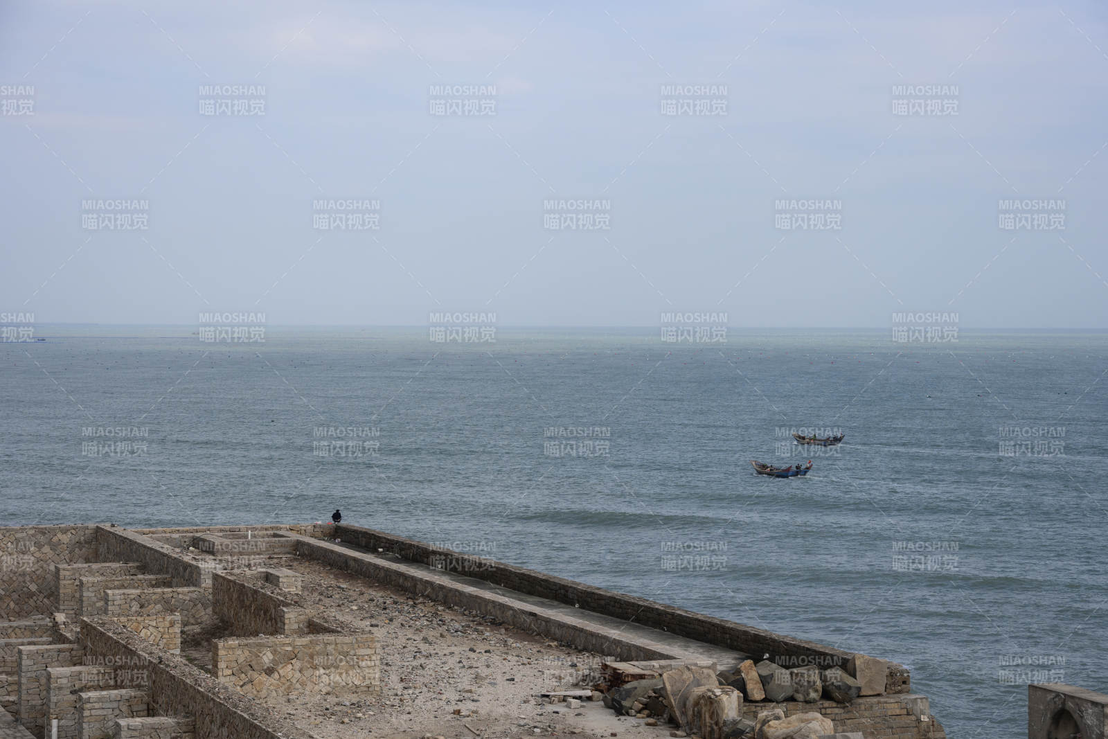 白塘湾海边石堤与小船图片