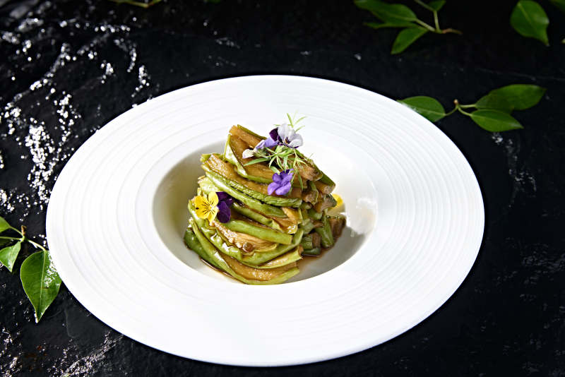 白色瓷盘装的腌渍酱佛手瓜切片图片