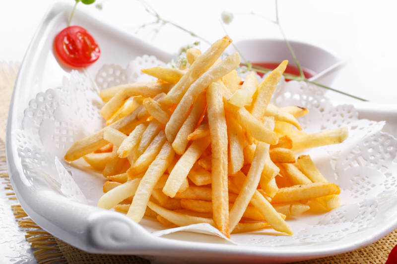 白色瓷盘装的油炸薯条图片