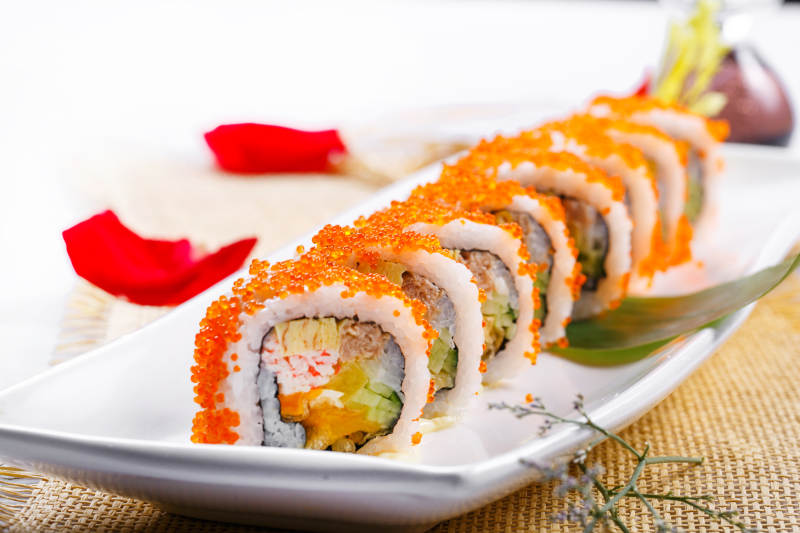 蟹子加州手卷寿司摆放在草垫上图片