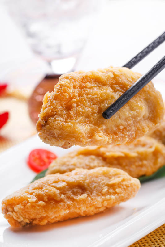 白色瓷盘装的香炸鸡翅中图片