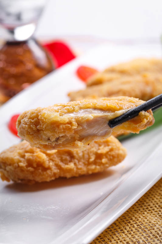 白色瓷盘装的香炸鸡翅中图片