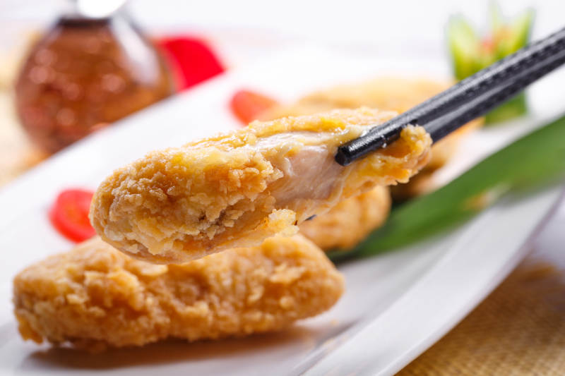 白色瓷盘装的香炸鸡翅中图片