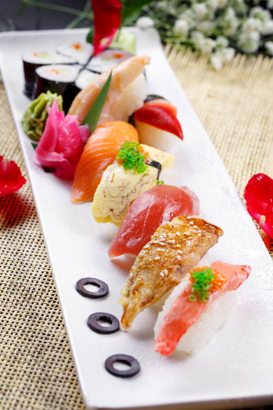 精美餐具装的高级手握寿司拼盘图片