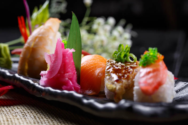 精美餐具装的高级手握寿司拼盘图片