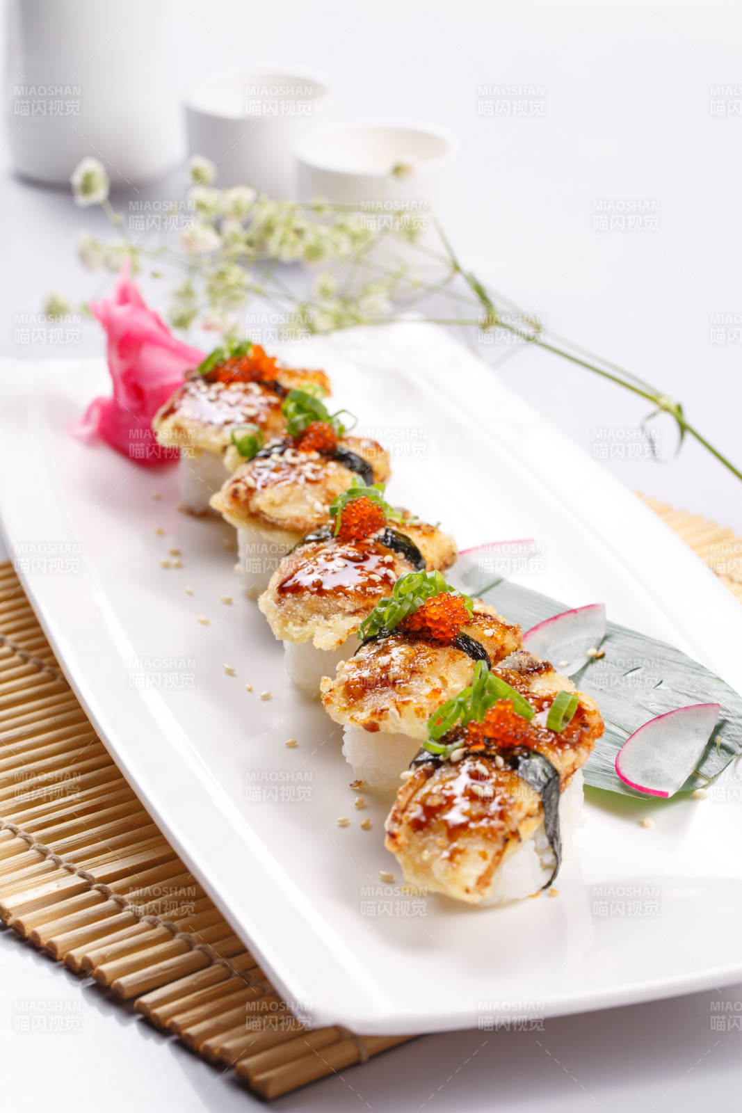 鳗鱼天妇罗手握寿司摆放在寿司帘上图片