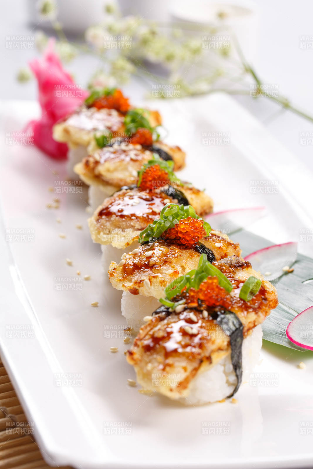 鳗鱼天妇罗手握寿司摆放在寿司帘上图片